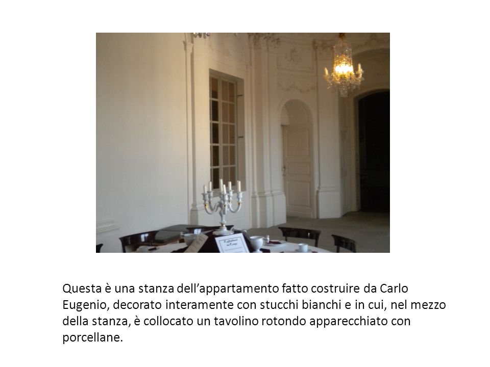 Questa è una stanza dell’appartamento fatto costruire da Carlo Eugenio, decorato interamente con stucchi bianchi e in cui, nel mezzo della stanza, è collocato un tavolino rotondo apparecchiato con porcellane.